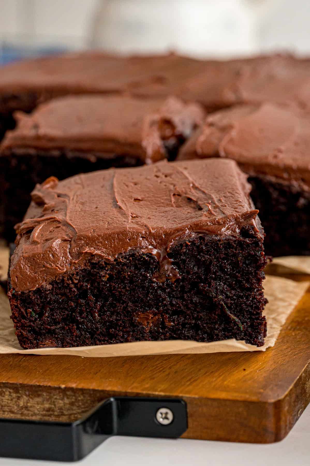 This Chocolate Zucchini Cake is rich, moist, and topped with an irresistible chocolate buttercream! It's a must-bake every summer! Slices of chocolate zucchini cake