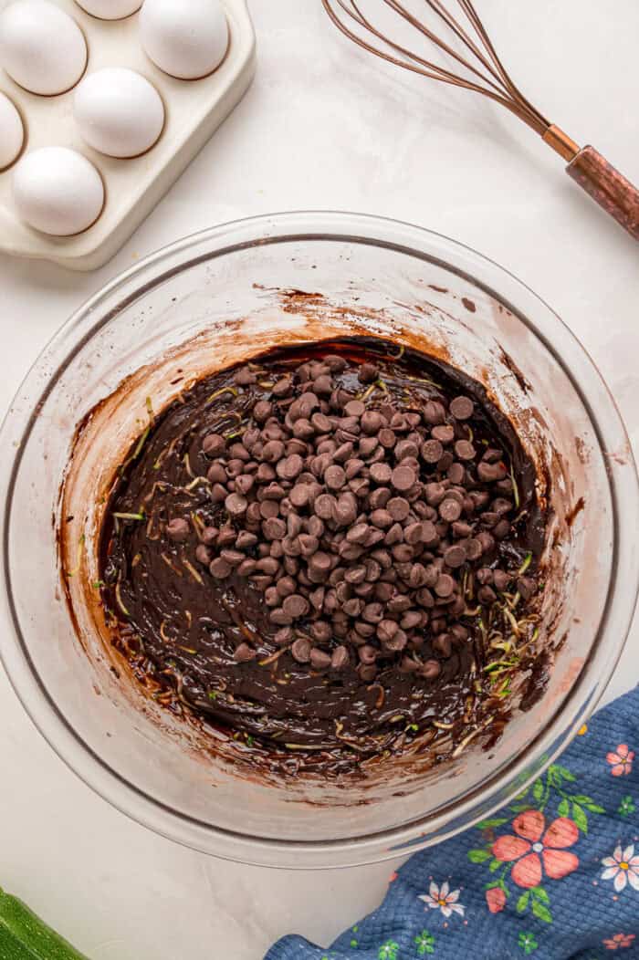 This Chocolate Zucchini Cake is rich, moist, and topped with an irresistible chocolate buttercream! It's a must-bake every summer! Adding chocolate chips to chocolate cake batter