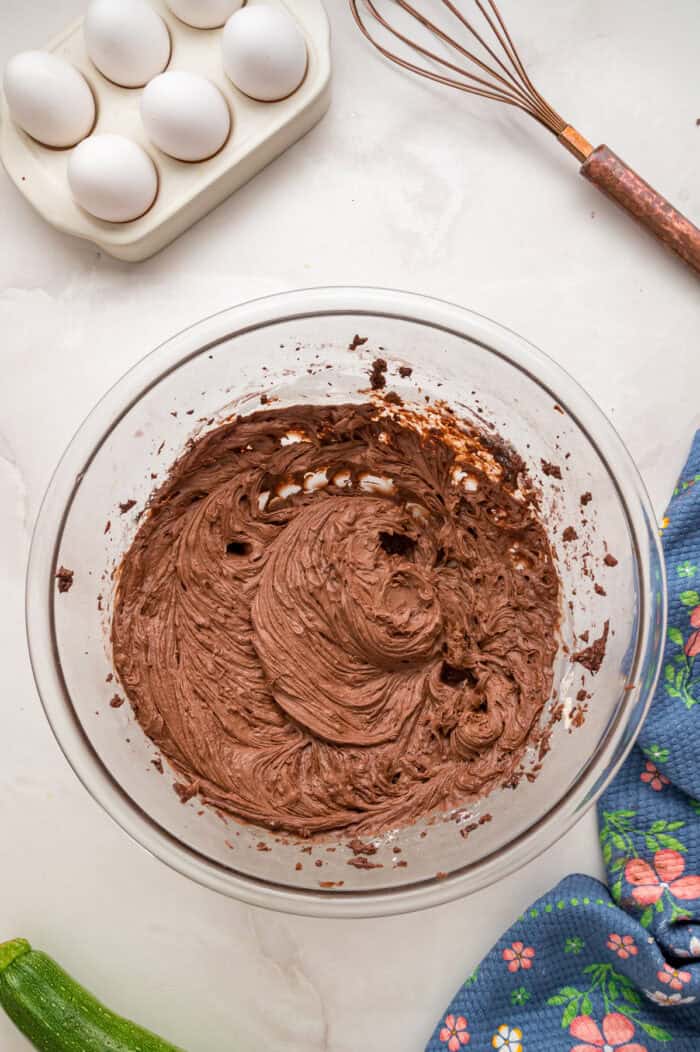 This Chocolate Zucchini Cake is rich, moist, and topped with an irresistible chocolate buttercream! It's a must-bake every summer! Chocolate buttercream in a bowl
