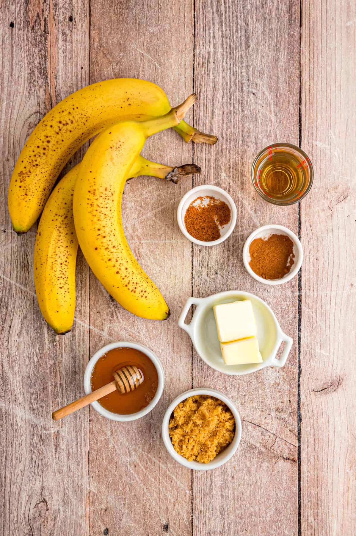 Banana slices are caramelized in a buttery brown sugar sauce in this easy Fried Bananas recipe. Serve over ice cream, pancakes, or waffles. Overhead view of ingredients needed to make fried bananas