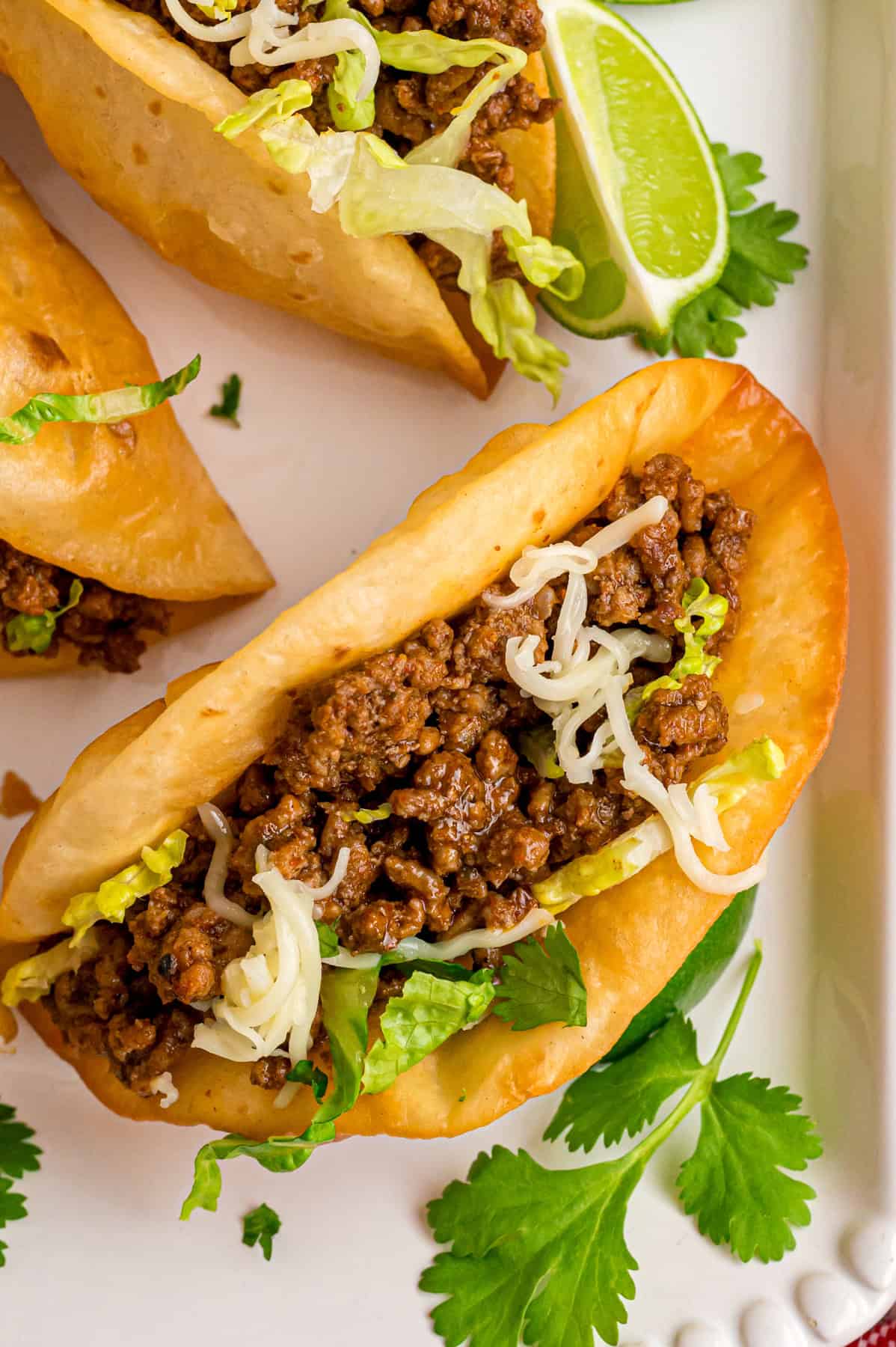 Seasoned meat is served in crunchy taco shells and loaded with toppings in this Ground Beef Tacos recipe. Ready in just 25 minutes! Overhead view of a ground beef taco