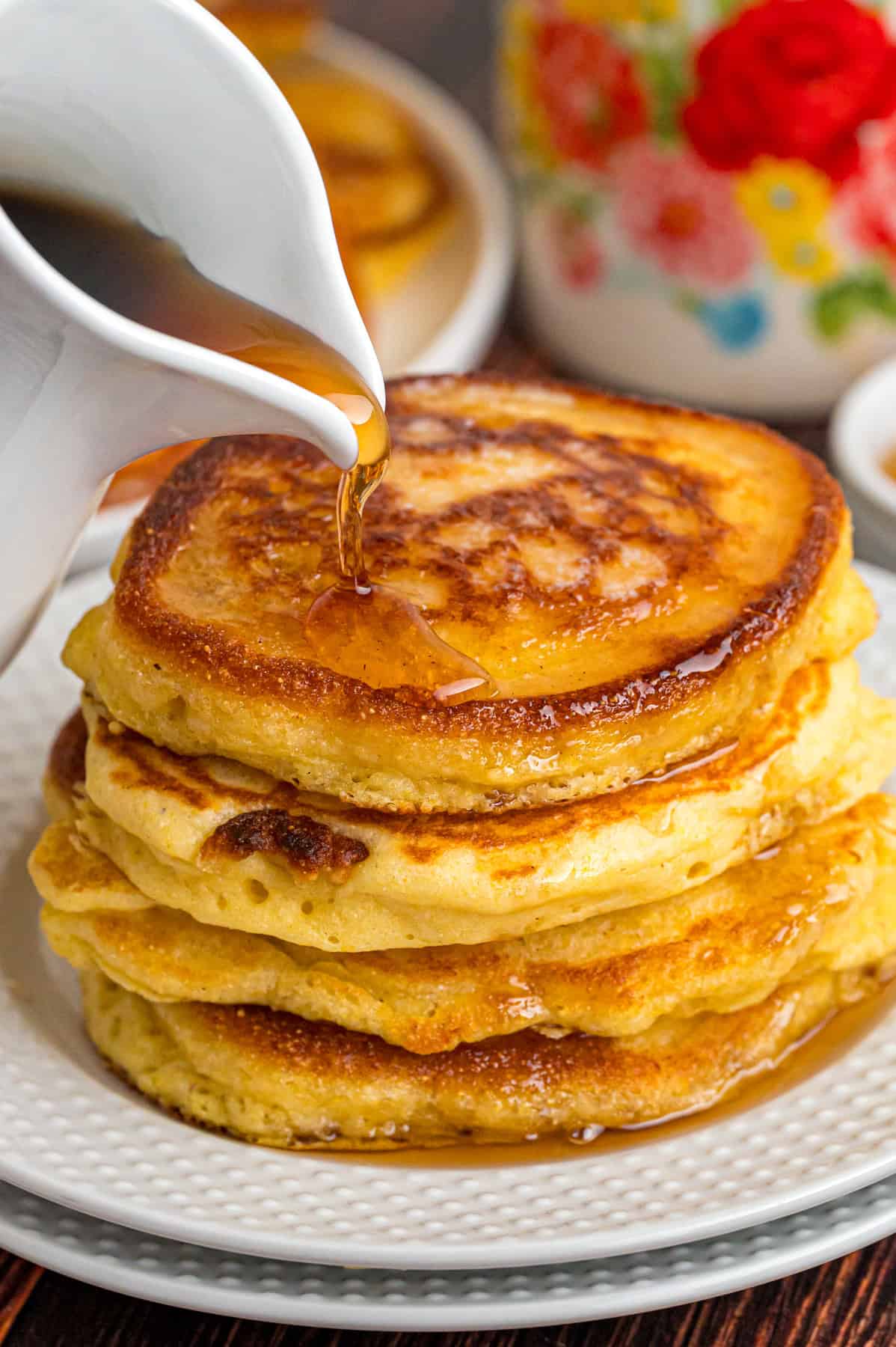 Pouring syrup over a stack of hoe cakes