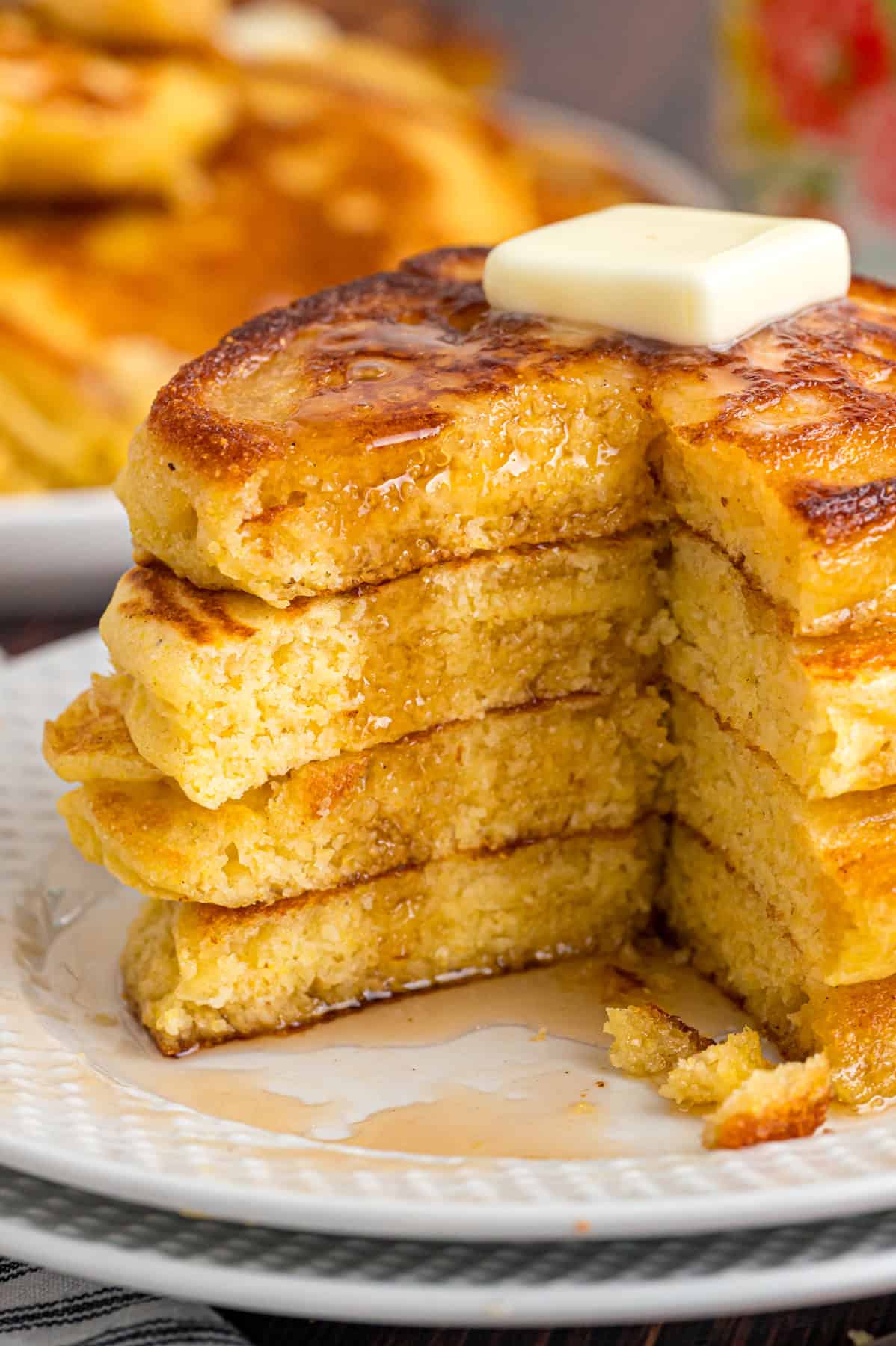 A stack of hoe cakes topped with butter and syrup