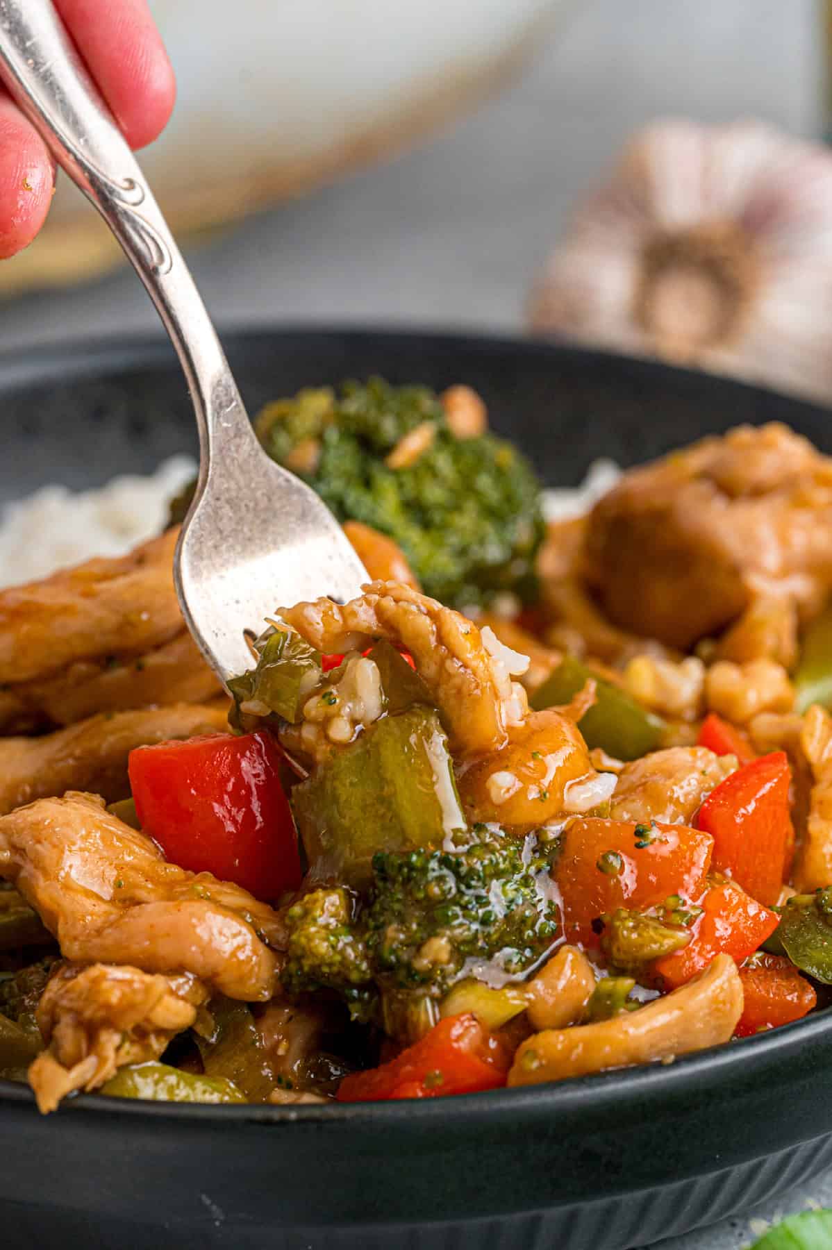 A fork in a bite of hunan chicken
