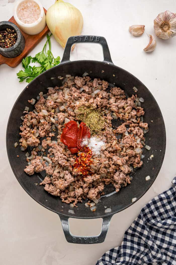 Ground beef and sausage and seasonings in a skillet