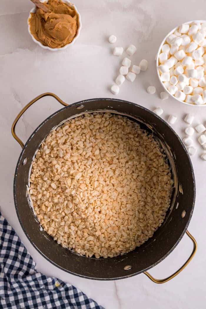 Folding crisped rice cereal into melted marshmallows