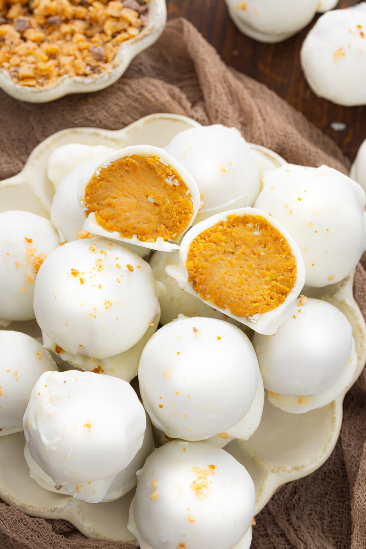 Pumpkin Truffles on a plate with one cut in half showing the inside