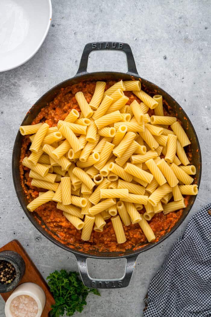 Rigatoni noodles added to bolognese sauce