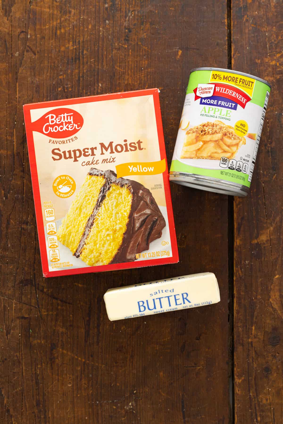 A box of yellow cake mix, apple pie filling, and a stick of butter