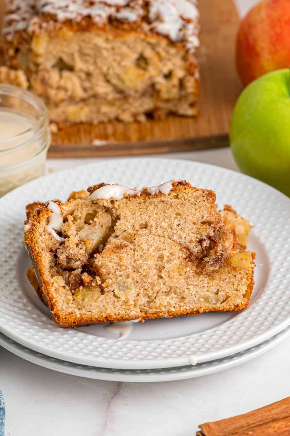 A slice of apple cinnamon bread on a white plate