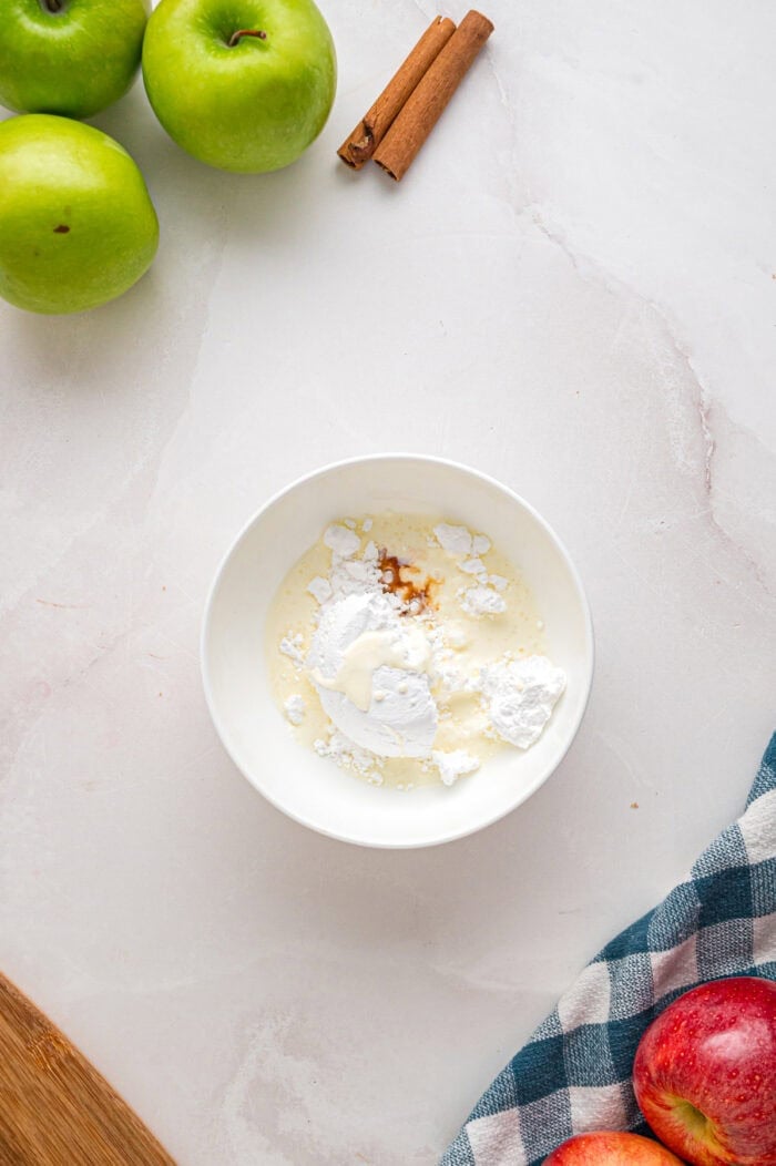 Powdered sugar, heavy cream, and vanilla in a bowl