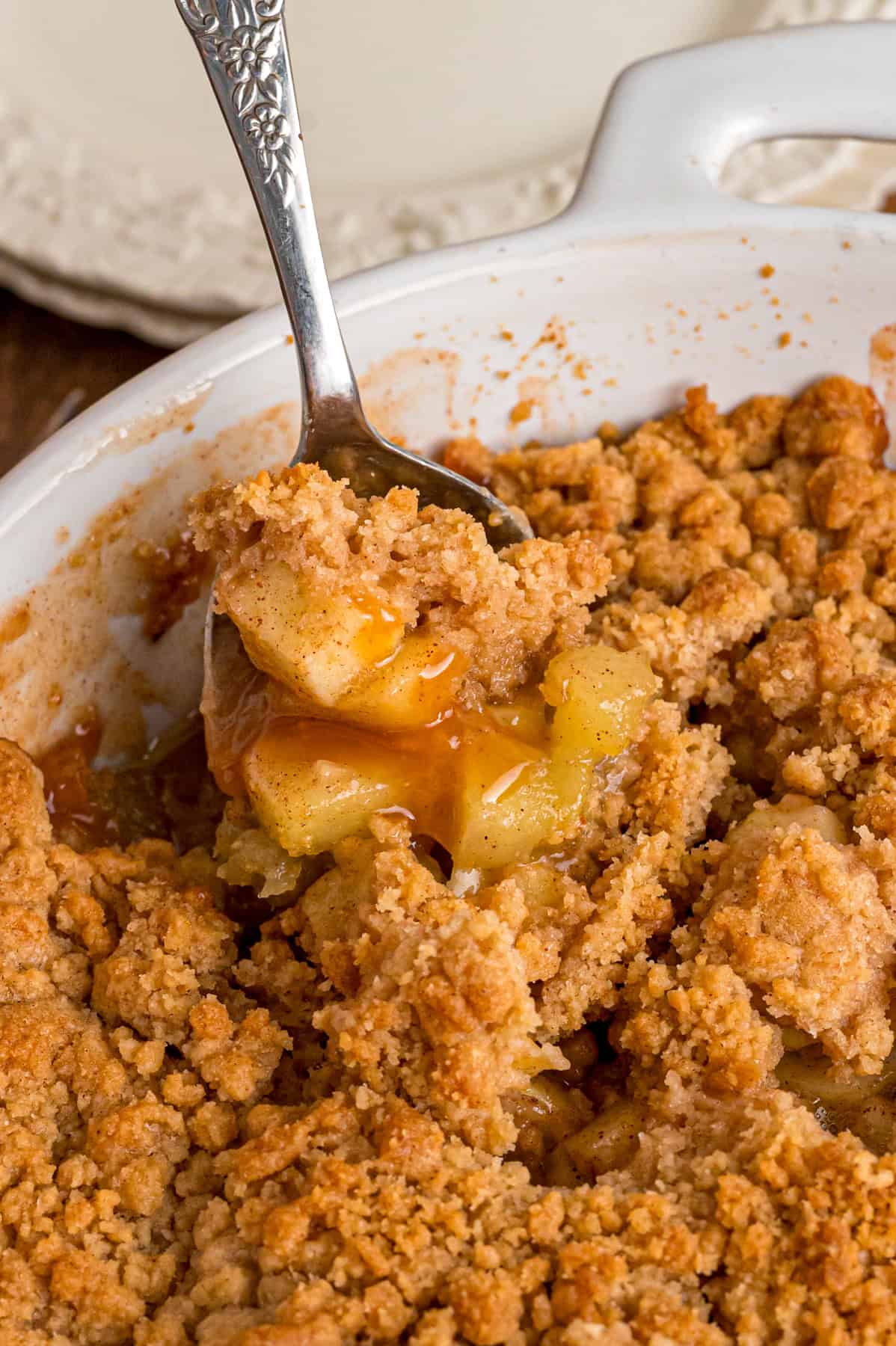 A spoon in a baking dish of apple crumble