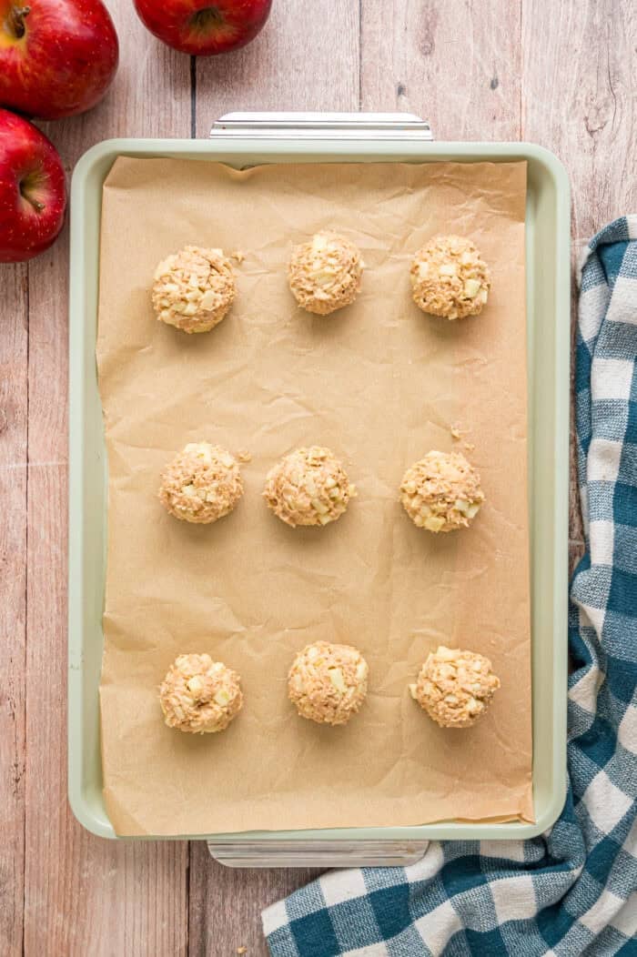Balls of apple oatmeal cookie dough on a baking sheet