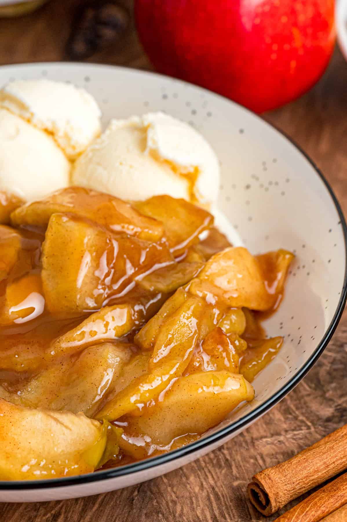 A bowl of baked apples with vanilla ice cream