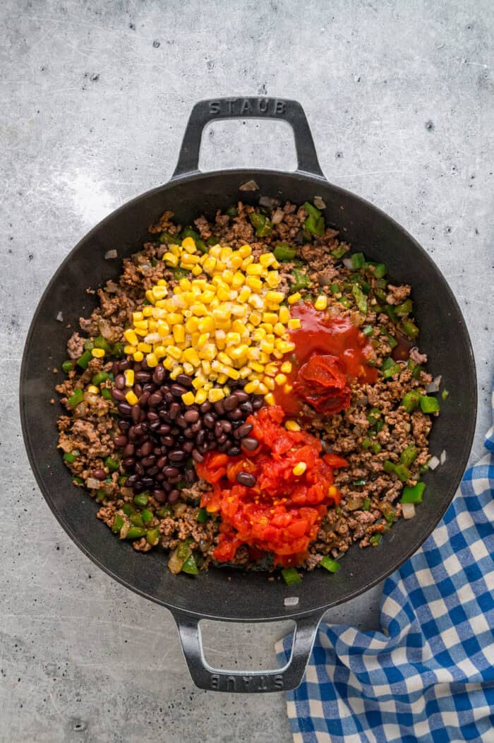 Corn, black beans, and tomato paste added to ground beef