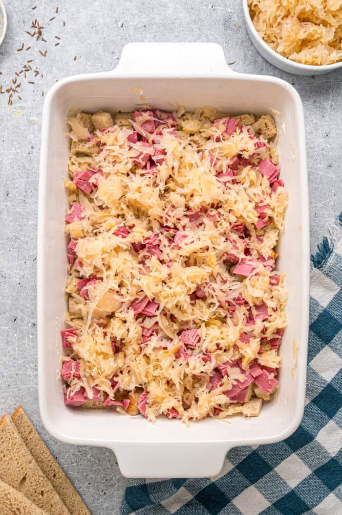 Rye bread, corned beef, and sauerkraut layered in a baking dish