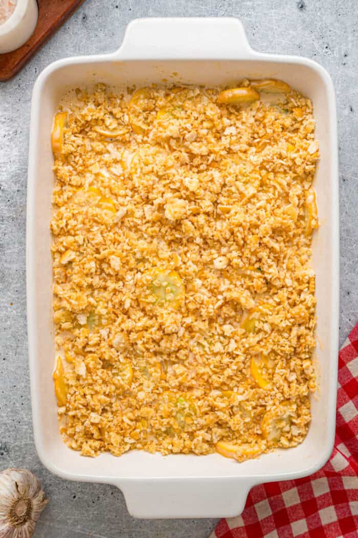 crushed crackers on top of squash casserole ready to be baked 
