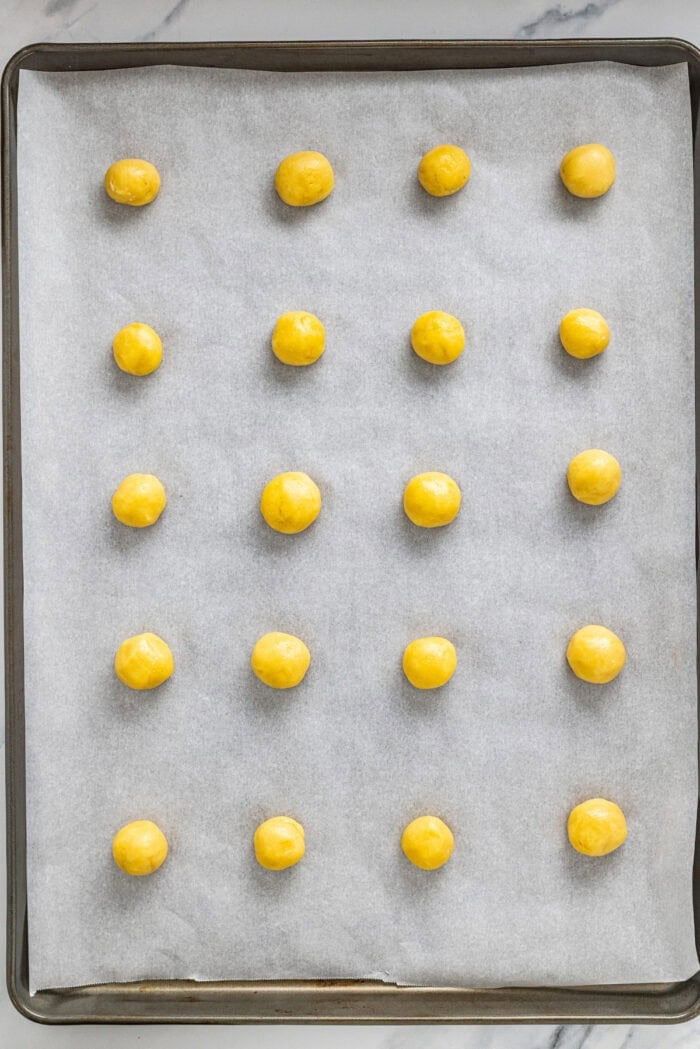 With a soft, buttery texture, the signature anise flavor, and simple decoration, these Anise Cookies are a holiday staple. Balls of cookie dough on a baking sheet