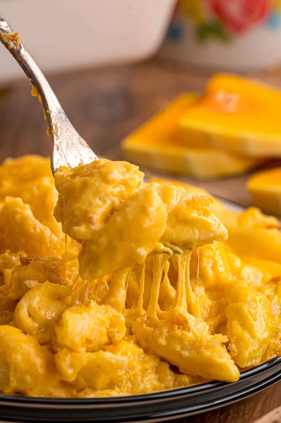 A fork in a plate of butternut squash mac and cheese