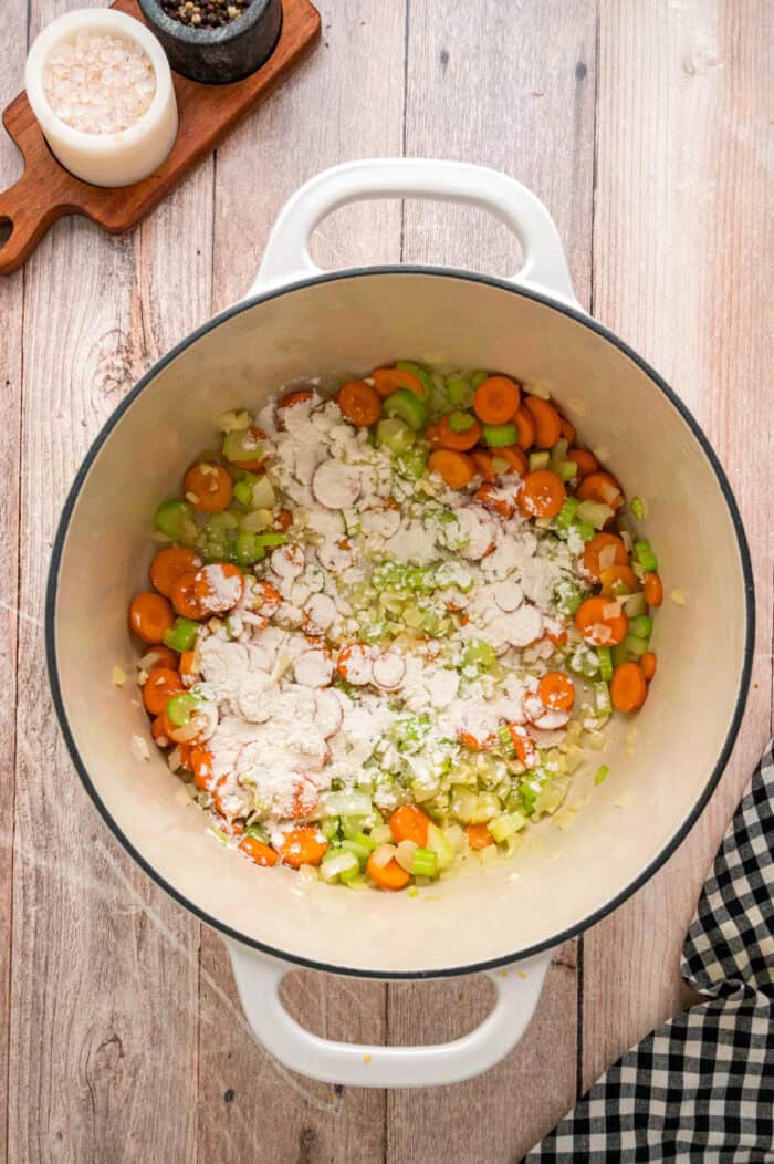 Ready in just under an hour, this Chicken and Rice Soup is quick, easy, and filling. Perfect for busy fall weeknights! Carrots, celery, onion, and flour in a pot