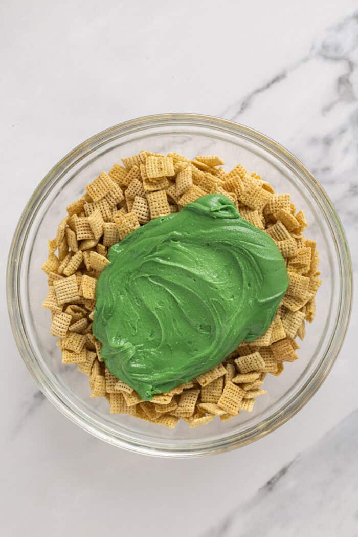 Melted green chocolate in a bowl with Chex cereal