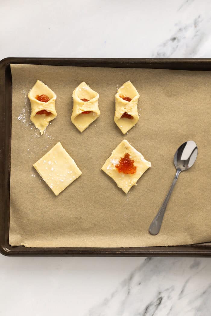 Kolaczki Cookies, aka Polish filled cookies, are made with a simple cream cheese dough and jam filling. They’re simple yet beautiful. Filling squares of cookie dough with jam