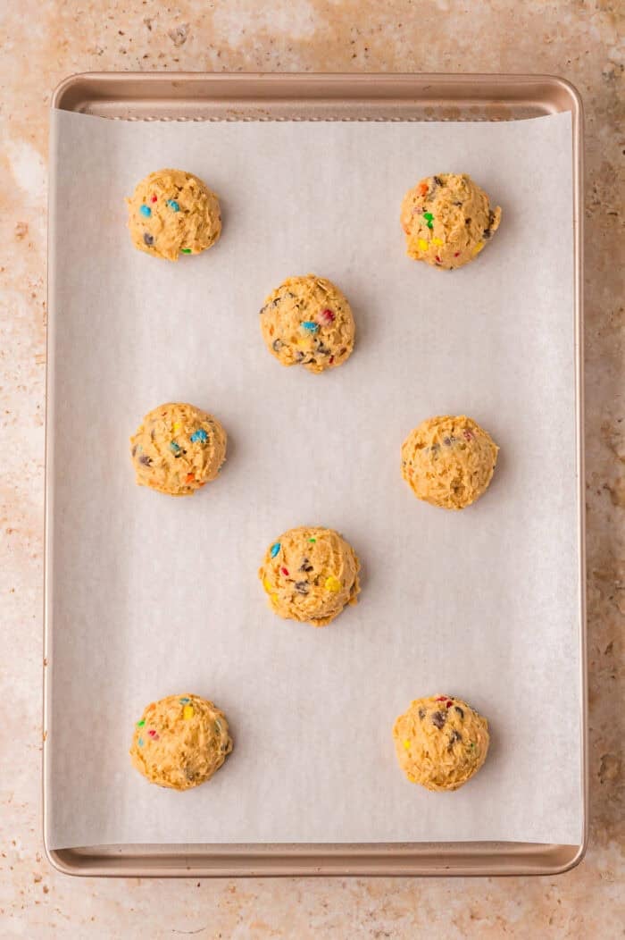 Large balls of cookie dough on a baking sheet