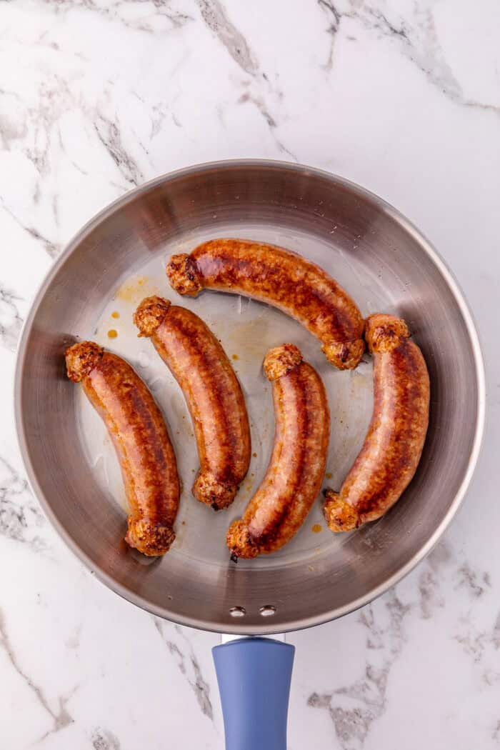 Italian sausage links searing in a pan