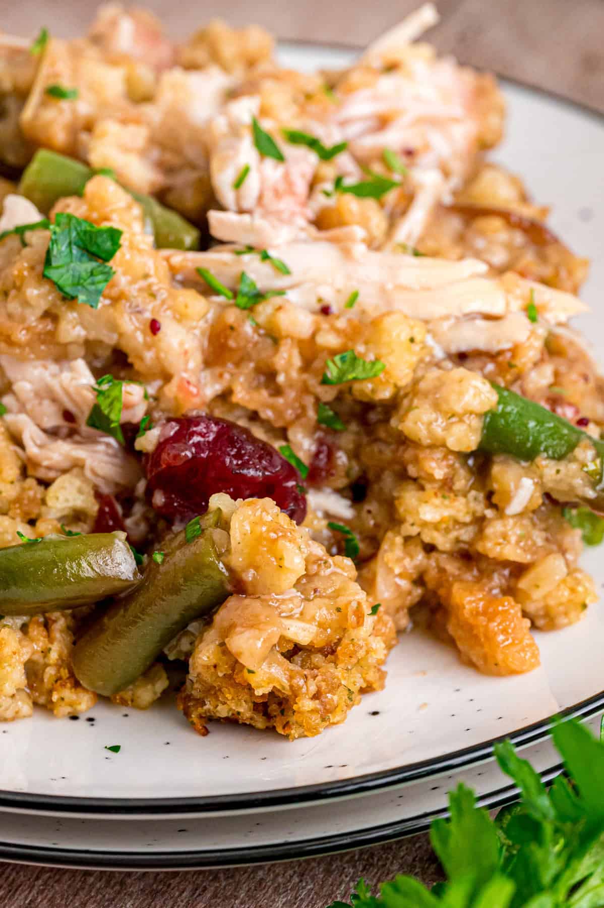 Turkey Stuffing Casserole is an easy way to repurpose Thanksgiving leftovers like turkey, gravy, cranberry sauce, and stuffing. Close up of a plate of turkey stuffing casserole