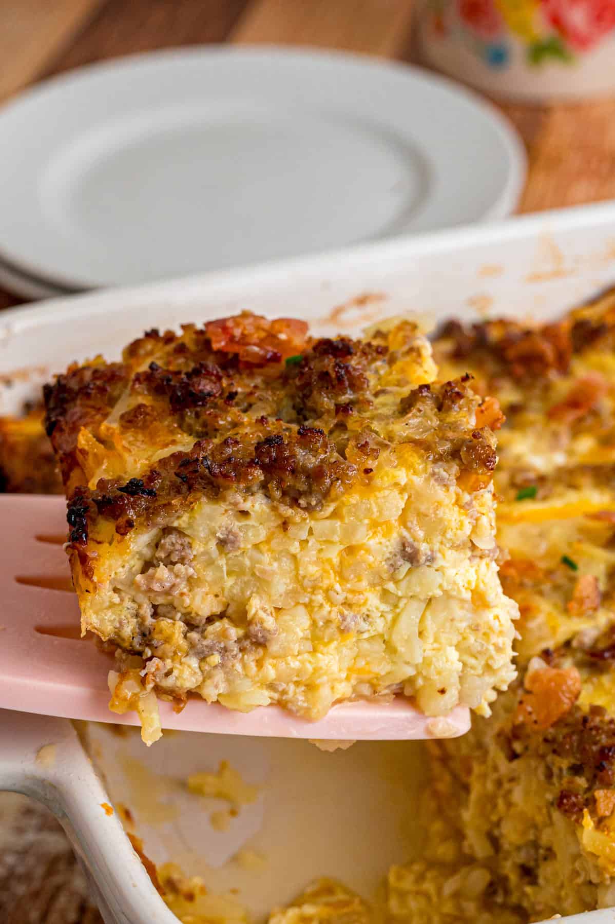Serving a slice of Amish breakfast casserole