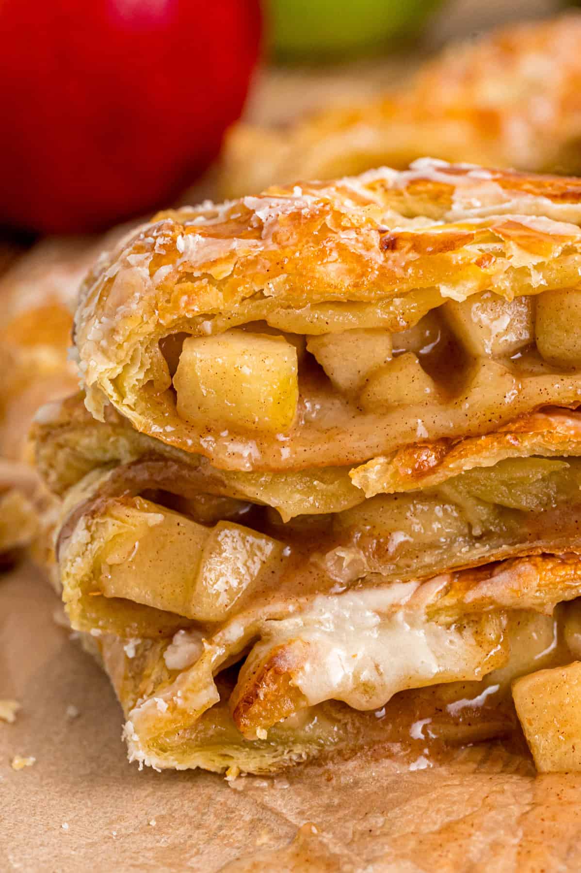 Warmly spiced apple filling is baked inside puff pastry sheets and topped with an irresistible maple glaze in this Apple Strudel recipe. Slices of apple strudel stacked on each other