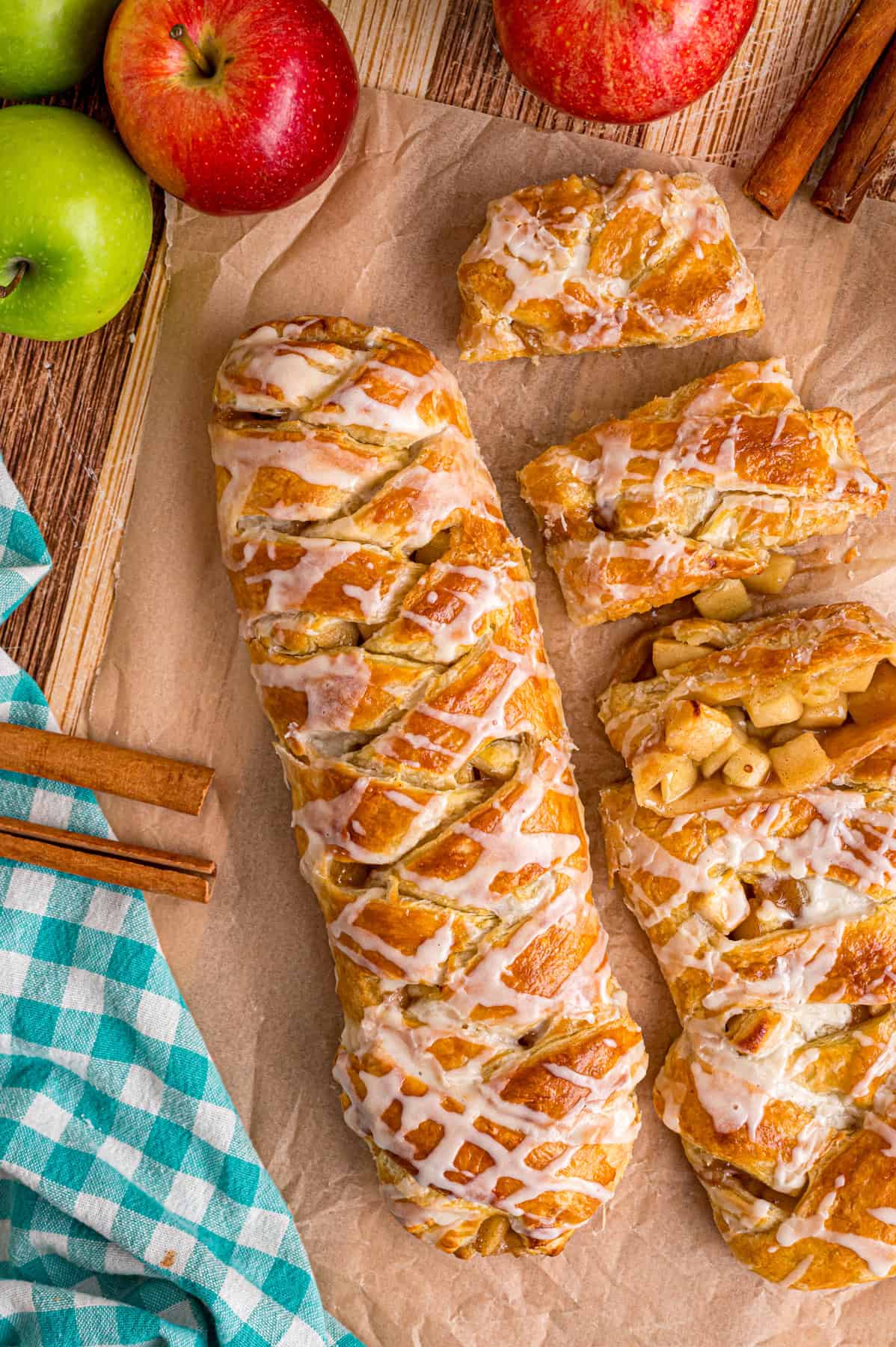 Warmly spiced apple filling is baked inside puff pastry sheets and topped with an irresistible maple glaze in this Apple Strudel recipe. Overhead view of two apple strudels, one sliced and the other whole