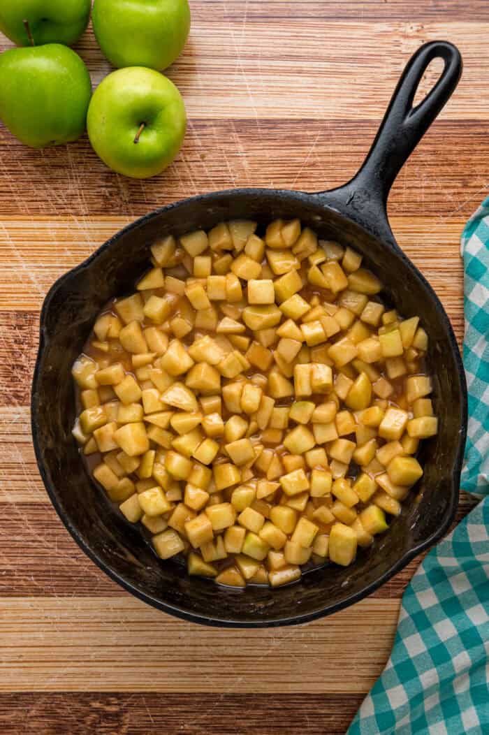 Warmly spiced apple filling is baked inside puff pastry sheets and topped with an irresistible maple glaze in this Apple Strudel recipe. Apple filling in a cast iron skillet