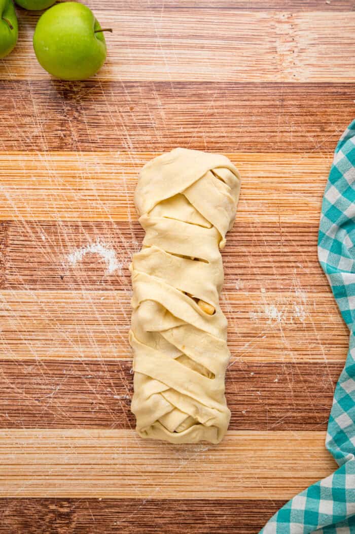 Warmly spiced apple filling is baked inside puff pastry sheets and topped with an irresistible maple glaze in this Apple Strudel recipe. Puff pastry braided around apple filling