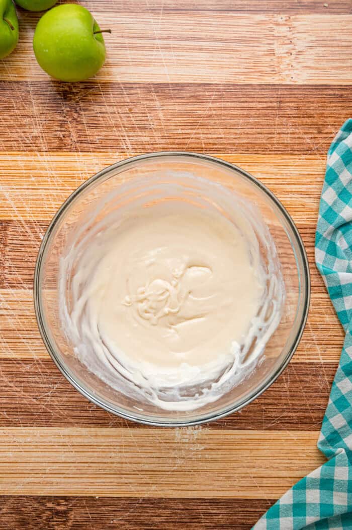 Warmly spiced apple filling is baked inside puff pastry sheets and topped with an irresistible maple glaze in this Apple Strudel recipe. Maple glaze in a bowl