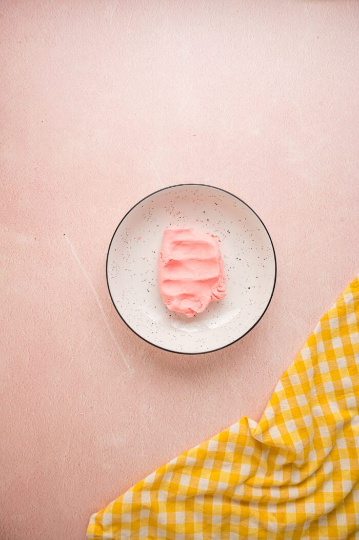These melt-in-your-mouth Butter Mints are made with just a few ingredients and require no cooking. Easy to customize! Pink mint dough on a plate