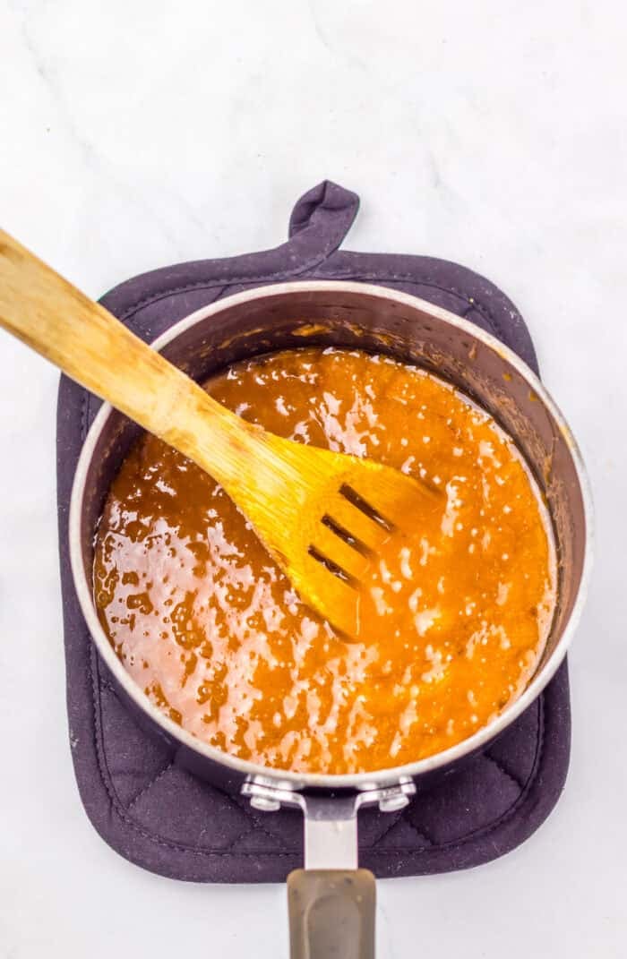 With just four ingredients, this Almond Roca Recipe features layers of almonds, toffee, and chocolate. Buttery, crunchy, and easy to make! Stirring toffee on the stovetop