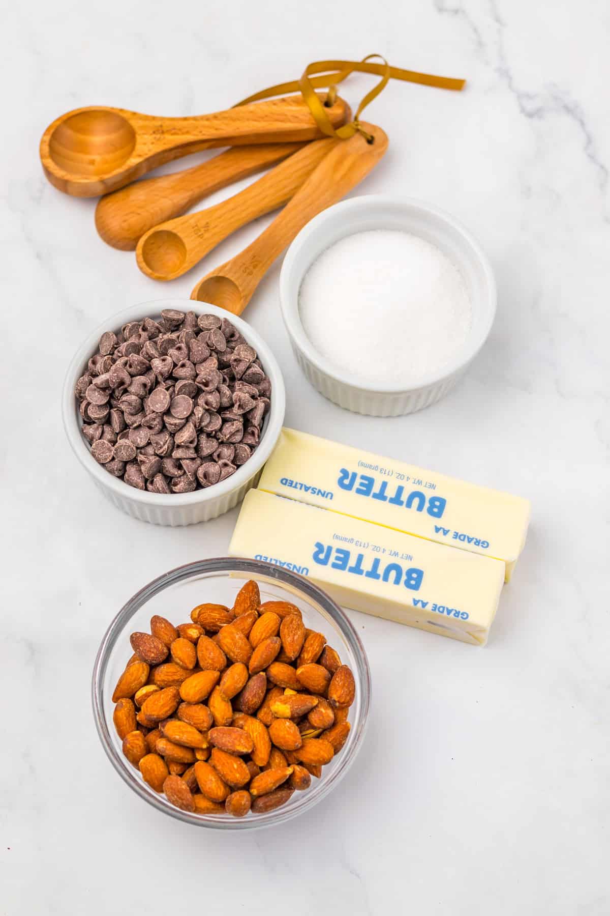 With just four ingredients, this Almond Roca Recipe features layers of almonds, toffee, and chocolate. Buttery, crunchy, and easy to make! Overhead view of ingredients needed to make an almond roca recipe