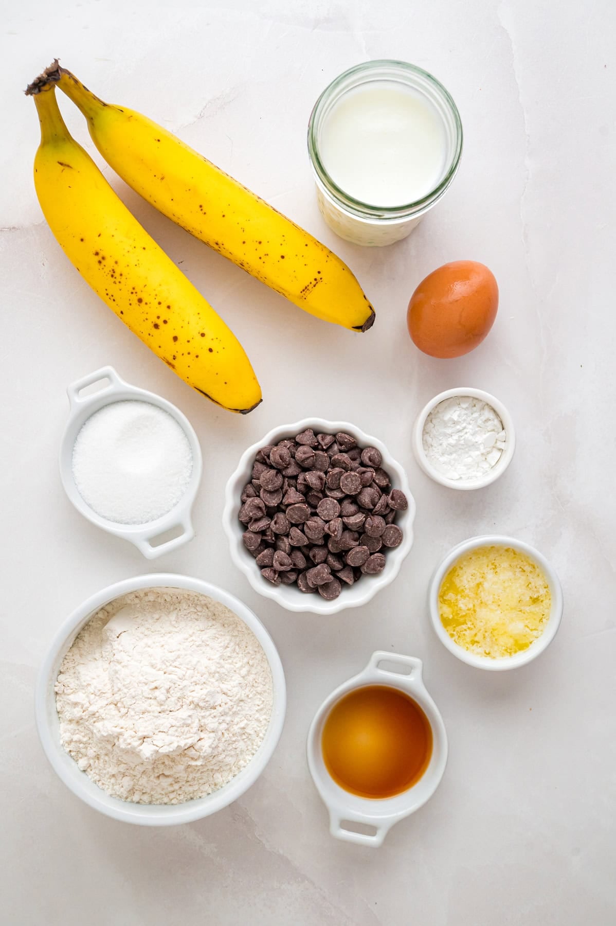 Every bite of these Banana Chocolate Chip Pancakes is dotted with chocolate chips and filled with sweet banana flavor. Overhead view of ingredients needed to make banana chocolate chip pancakes