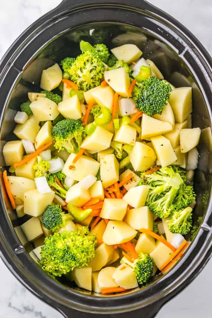 Broccoli, potatoes, carrots, and onion in a slow cooker