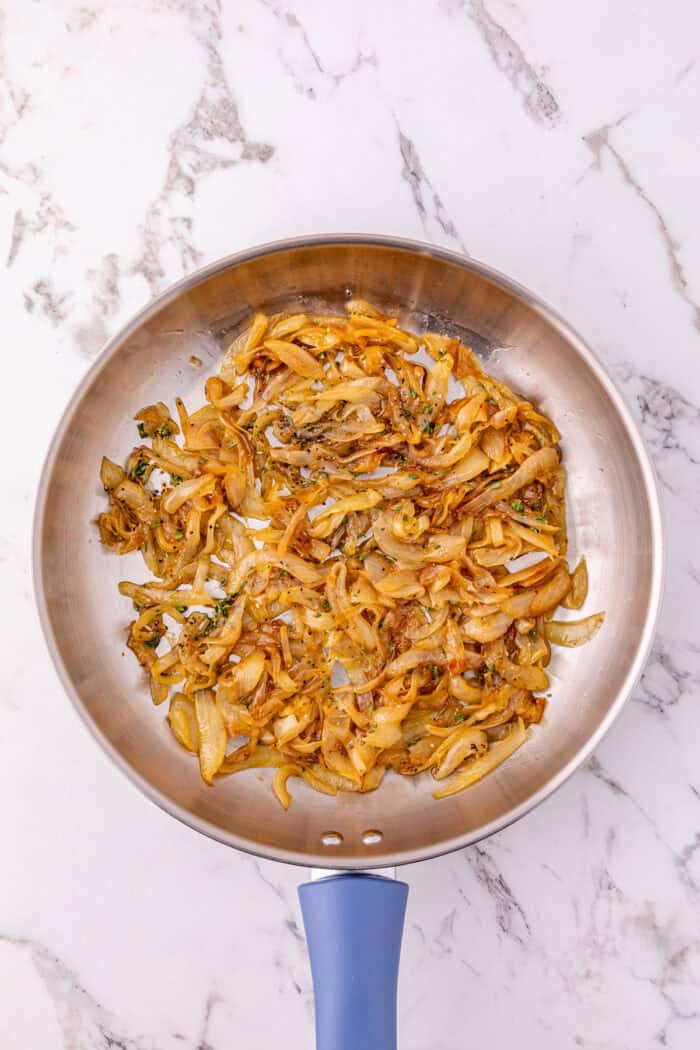 Roast beef, caramelized onions, and Swiss cheese are layered on Hawaiian rolls to make these easy French Dip Sliders. Caramelized onions in a pan