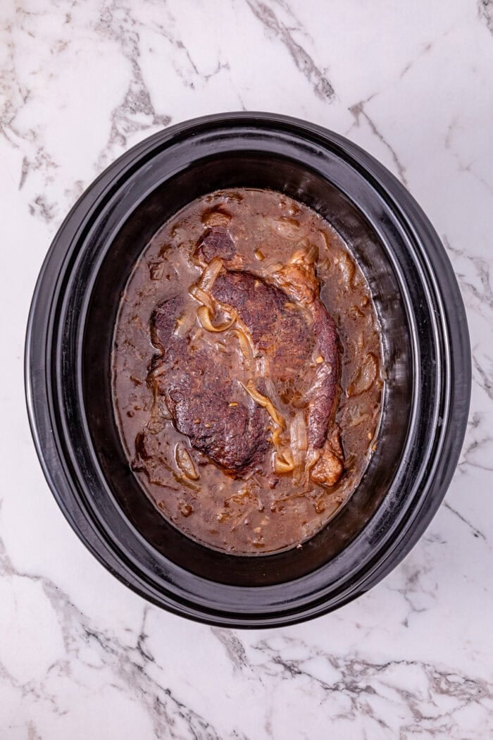 Seared chuck roast is slow cooked in savory broth and onion soup mix until fall-apart tender in this Slow Cooker French Onion Pot Roast. French onion pot roast in the slow cooker