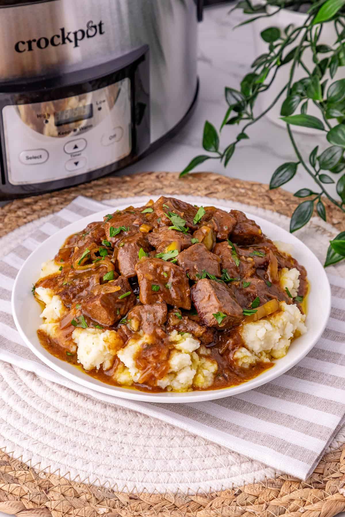 These Mississippi Steak Bites are savory, tangy, and so tender, with chunks of sirloin with ranch seasoning, au jus gravy, and pepperoncini. A plate of Mississippi steak bites over potatoes
