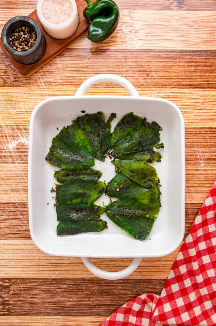 Poblano peppers in the bottom of a baking dish