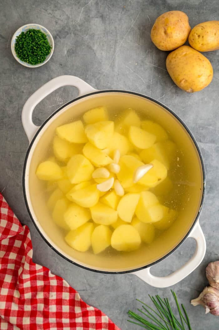 Chunks of potatoes and garlic in a pot wtih water