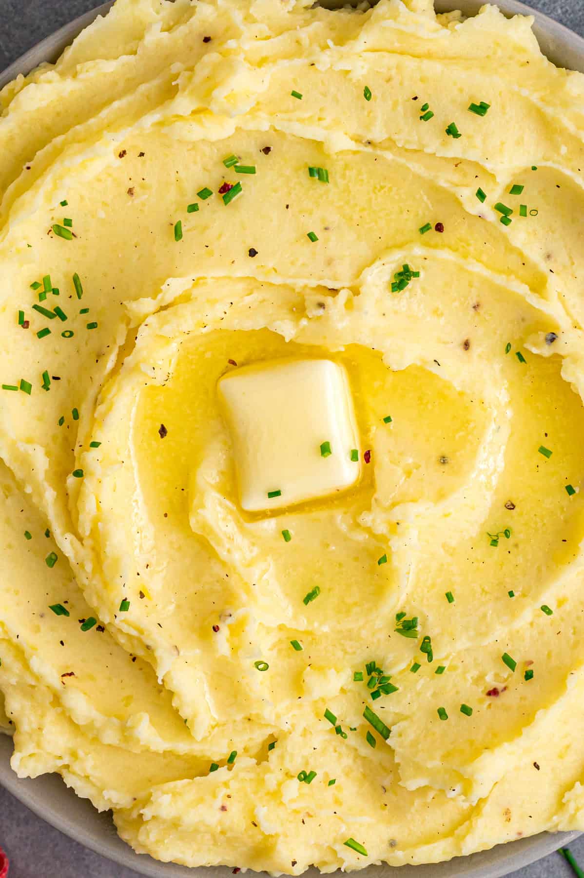 Close up of dollop of butter on creamy garlic mashed potatoes