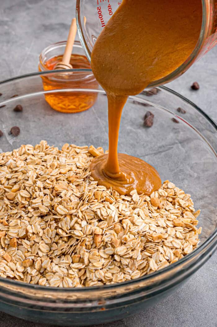Sweet, nutty, and crunchy, this Peanut Butter Granola is better than anything that can be bought at the store! Pouring peanut butter mixture over oats