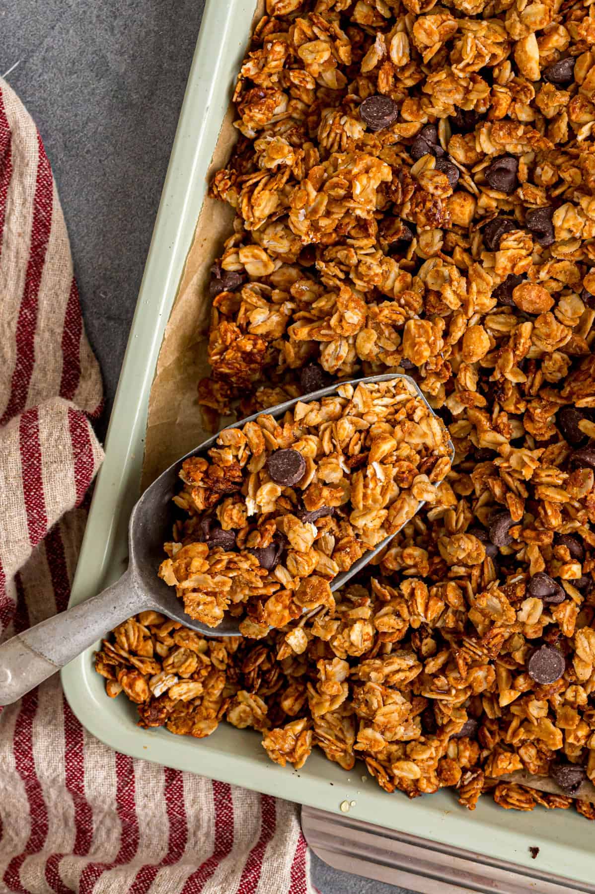Sweet, nutty, and crunchy, this Peanut Butter Granola is better than anything that can be bought at the store! A scoop of peanut butter granola over a baking sheet