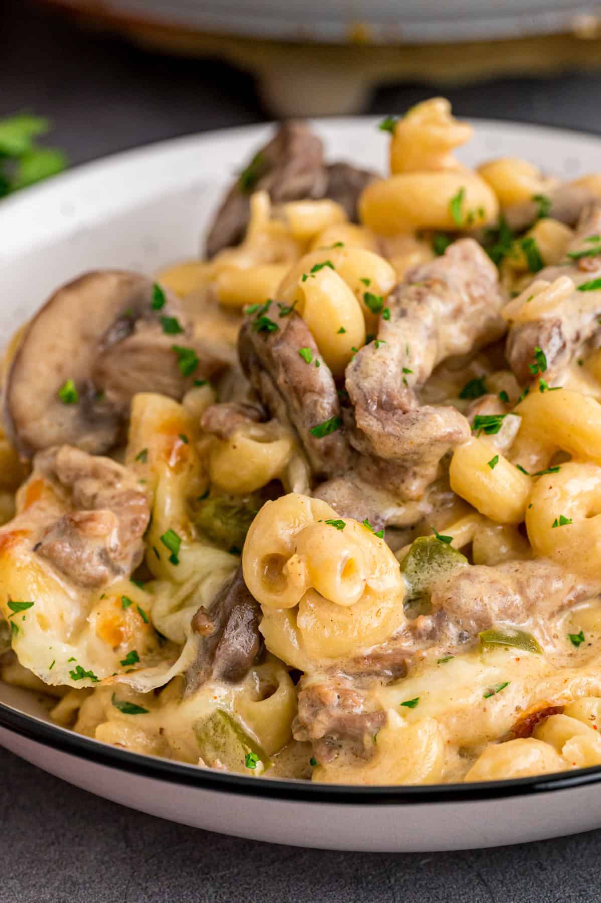 Loaded with sliced ribeye, peppers, onions, mushrooms, and lots of cheese, this Philly Cheesesteak Pasta is an easy one-pan dinner. A bowl of Philly cheesesteak pasta