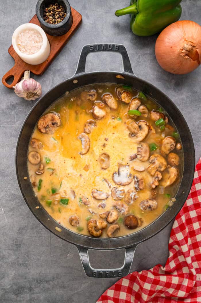 Loaded with sliced ribeye, peppers, onions, mushrooms, and lots of cheese, this Philly Cheesesteak Pasta is an easy one-pan dinner. Beef broth and heavy cream added to the pot with veggies